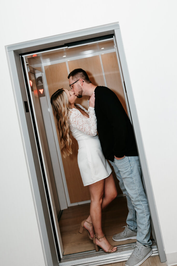 A couple kissing in an elevator durrign their engagement session in Nisswa, Minnesota