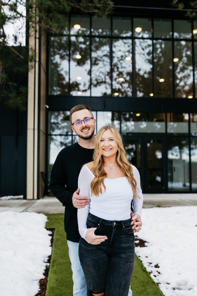 A happy couple smiling at the camera in front of their wedding venue, Catalyst by Nature Link