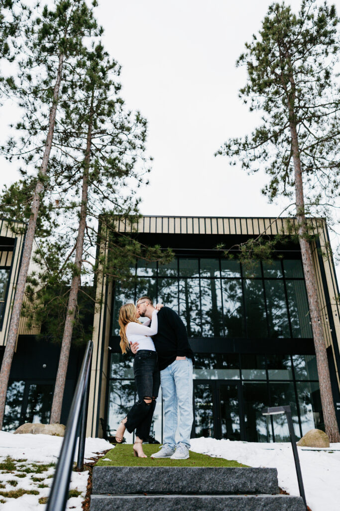 A romantic kiss shared between an engaged couple at their wedding venue, Catalyst by Nature Link in Nisswa, Minnesota